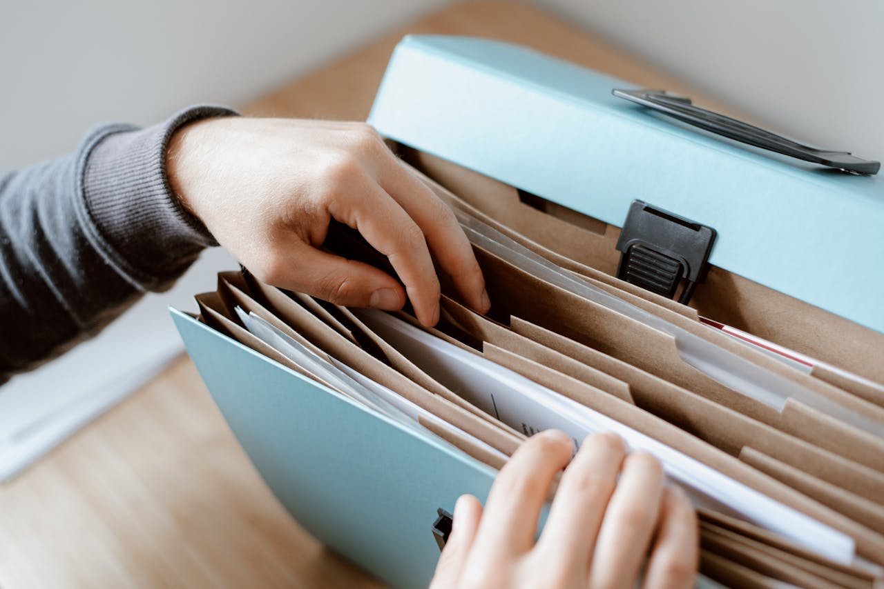 person-choosing-document-in-folder-4792285